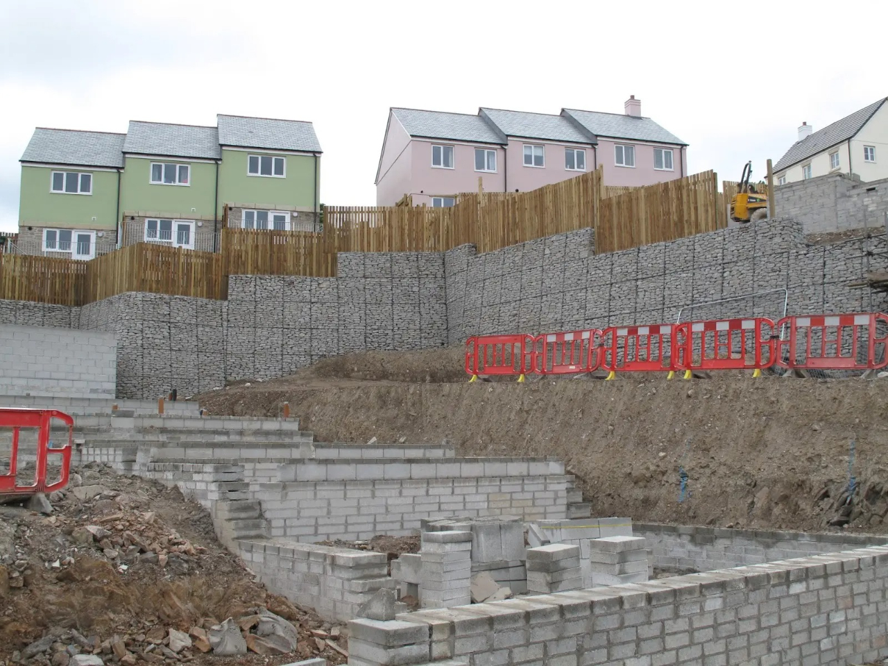 Stone wall with wooden fence and houses