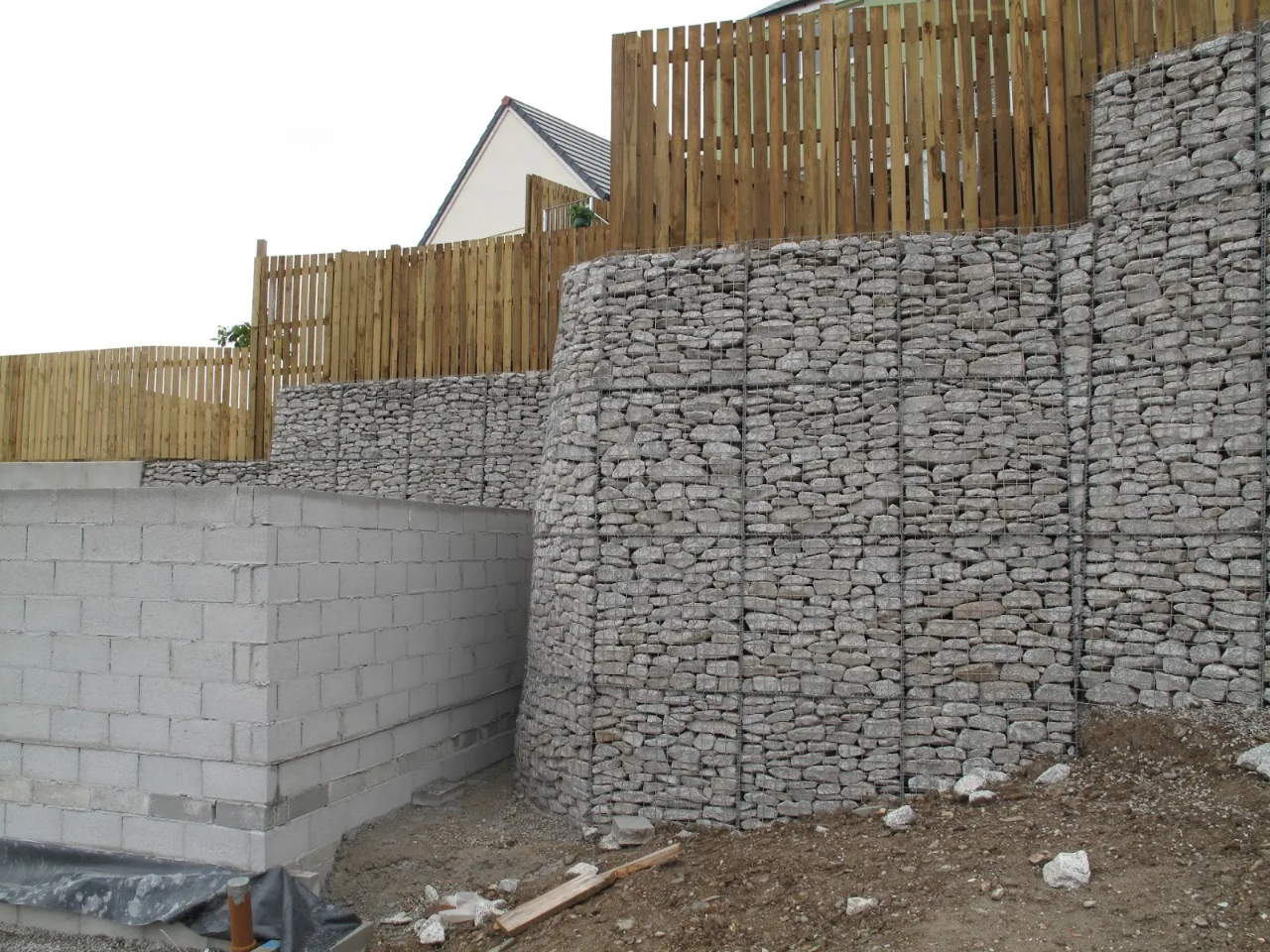 stone wall with wooden fence and building